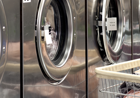 Row Of Washers With Cart Of Clothes
